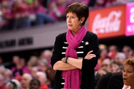 Muffet McGraw in a black sweater watches a match at the sidelines.